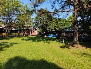a large yard with a tree and a house at Cabañas Las Moras in Candelaria