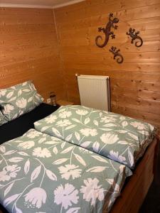 a bedroom with a bed with a green and white comforter at Waldhaus Wangen in Burg-Reuland