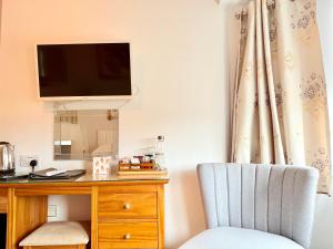 a room with a desk with a tv and a chair at Oxford Guest House in Oxford
