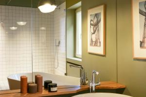 a bathroom with a sink and a tub and a mirror at GRAACE House Suites in Luxembourg +46 photos