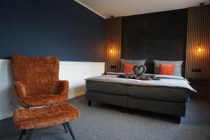 a bedroom with a chair and a bed and a chair at Hotel Groote Engel in Emlichheim