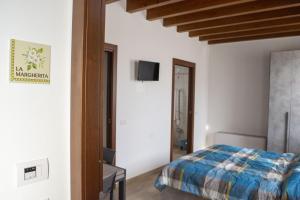 a bedroom with a bed and a tv on a wall at Gaspari Farm Relais in Volta Mantovana