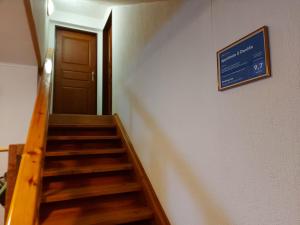 a stairway with a blue sign on the wall and a door at Apartmán U Davida in Chvaleč