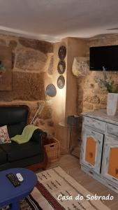 a living room with a couch and a tv at Casa do Sobrado-Gralhas-Montalegre in Gralhas