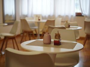 a table with a vase on top of it with chairs at Oasi Santa Rosa in Rome