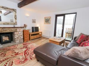 a living room with a couch and a fireplace at Ivy Cottage in Abergele