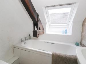 a white bath tub in a bathroom with a window at Ivy Cottage in Abergele +24 photos