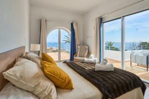 a bedroom with a large bed with a view of the ocean at Villa Mar Gran in Cacla D'or +36 photos