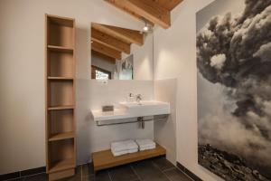 a bathroom with a sink and a painting on the wall at Haus Kristall inkl der SUPER SOMMER CARD im SOMMER 2026 in Serfaus +42 photos