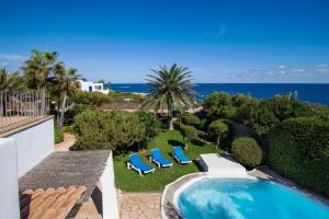 a backyard with a swimming pool and chairs and the ocean at Villa Mar Gran in Cacla D'or