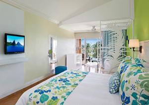 a bedroom with a bed and a tv on a wall at Coconut Bay Beach Resort & Spa All Inclusive in Vieux Fort