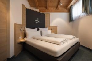 a bedroom with two beds with white sheets at Haus Kristall inkl der SUPER SOMMER CARD im SOMMER 2026 in Serfaus