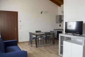 a living room with a table with chairs and a television at Gaspari Farm Relais in Volta Mantovana