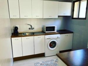 a kitchen with a washing machine and a microwave at PLAYA Y PISCINA Intiyan PONDOS in Almuñécar