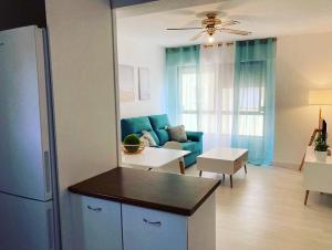 a living room with a blue couch and a table at PLAYA Y PISCINA Intiyan PONDOS in Almuñécar