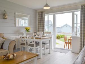 a kitchen and living room with a table and chairs at Pine View Cottage in Filey
