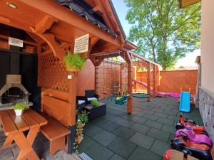 a backyard patio with a wooden pergola and a playground at Willa Sichelscy - apartamenty i pokoje z aneksami kuchennymi - rabat 20 procent na Termy Szaflary oraz Gorący Potok oraz 15 procent rabatu na Bramę Gorce in Biały Dunajec