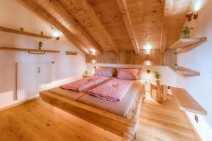 a bedroom with a large bed in a room with wooden ceilings at Bergliebe in Schleching