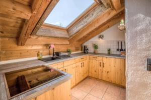 a kitchen with wooden cabinets and a skylight at Bergliebe in Schleching