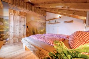 a bedroom with a bed and a wooden wall at Bergliebe in Schleching