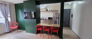 a kitchen with red chairs and a counter in a room at Apto térreo aconchego e localização central in Santa Rosa +10 photos