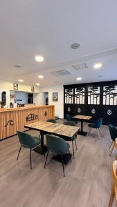 a cafeteria with tables and chairs in a room at Hôtel Paris Madrid avec Piscine et restauration in Lesperon