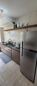 a kitchen with a stainless steel refrigerator in it at Apto térreo aconchego e localização central in Santa Rosa