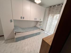 a small room with white cabinets and a bed at Nuovo Sile in Cavallino-Treporti