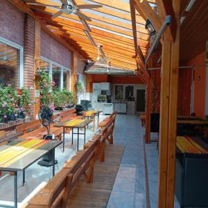 a patio with wooden tables and benches in a building at Békési Apartmanok in Békés