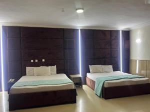 two beds in a room with purple walls at DE-George's Grand Resort in Mama