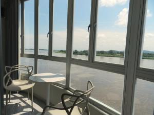 a table and chairs in front of a window with water at Panorama 1947 - Hotel Boutique Galería in El Banco