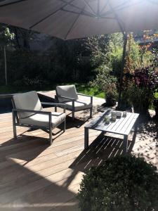 two benches and an umbrella on a wooden deck at Suite JULIETTE Chambre d'hôte de charme in Mulhouse