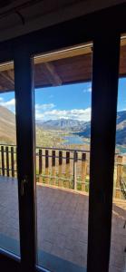 a door with a view of the mountains from a balcony at La Magia del Lago in Ranzanico