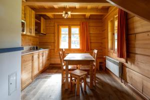 a kitchen with a table and chairs in a cabin at Osada Chytrusówka Bieszczady Bystre in Baligród