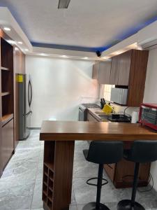 a kitchen with a wooden table and two bar stools at Casa Pacifico Azul in Ixtapa