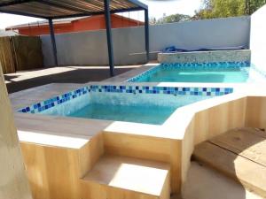 a swimming pool with a bench in the middle at Kings Rest Bed And Breakfast in Gaborone