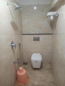 a bathroom with a white toilet in a stall at KSM Rooms in Tiruvannāmalai