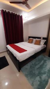 a bedroom with a large bed with a red blanket at KSM Rooms in Tiruvannāmalai