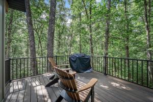 a deck with two chairs and a table with a tent on it at NEW - Treehouse - Dogwood in Jonesburg