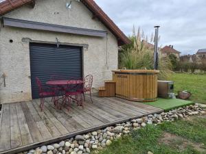 a patio with a table and chairs on a deck at TREE LODGY - LINAE - Nouveau espace bien être disponible in Ray-sur-Saône