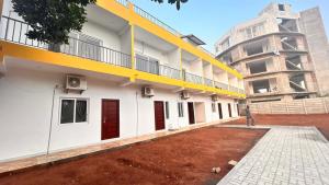 a building with yellow and white walls and a person standing outside at La nature in Pondicherry