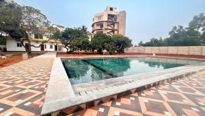 a swimming pool with a building in the background at La nature in Pondicherry