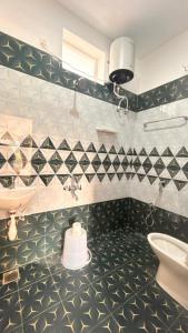 a bathroom with black and white tiled walls and a sink at La nature in Pondicherry