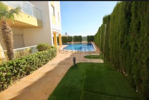 a swimming pool in a yard next to a building at résidence 2 chambres avec piscine proche mer in Orihuela Costa