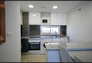 a kitchen with white cabinets and a sink and a dishwasher at résidence 2 chambres avec piscine proche mer in Orihuela Costa