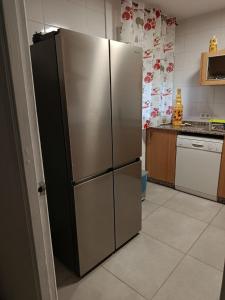 a stainless steel refrigerator in a kitchen at Chalet Lanzada in Sanxenxo
