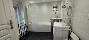 a bathroom with a white tub and a sink and a bath tub at Gîte Le Lyséas 6 personnes proche Forêt de Mormal & Animaux bienvenus in Bousies +17 photos
