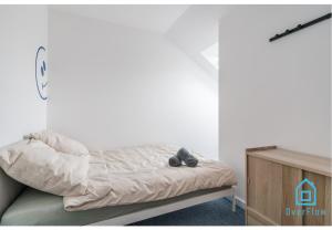 a bed with a pair of shoes sitting on it at Sunlight Room - 15 min to Old Town Gdansk in Gdańsk