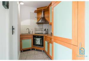 a kitchen with wooden cabinets and a stove top oven at Sunlight Room - 15 min to Old Town Gdansk in Gdańsk