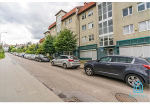 a row of cars parked on the side of a street at Sunlight Room - 15 min to Old Town Gdansk in Gdańsk